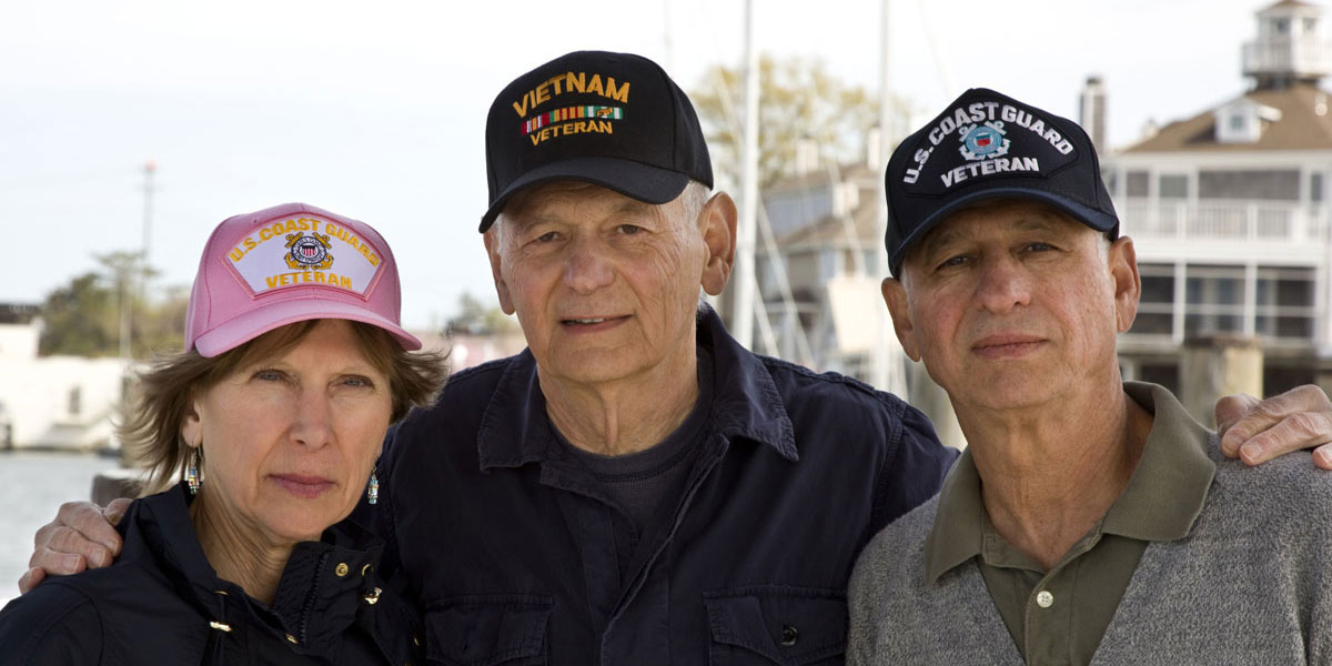 Veterans pose together by the water, representing the spirit of the upcoming veterans benefits event at Meadowview of Johnston.