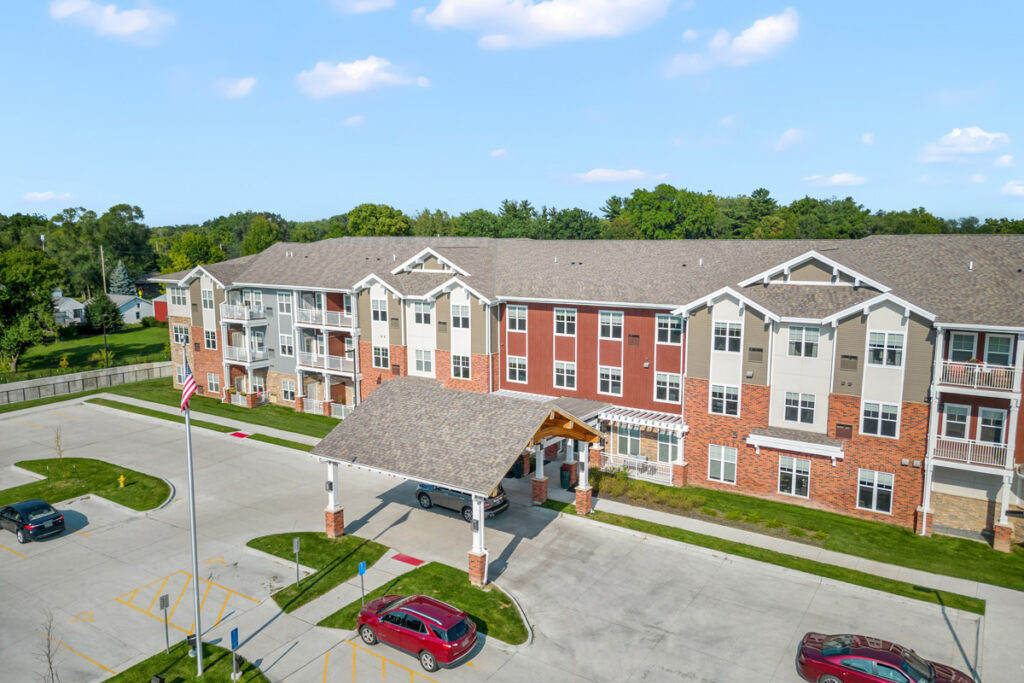Aerial view of Meadowview of Johnston senior living community in Johnston, Iowa, showcasing the residential building, covered entrance, and ground