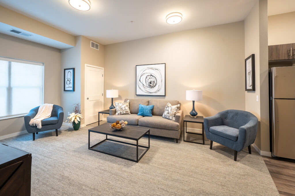 Spacious apartment living room at Meadowview of Johnston featuring comfortable seating, natural light, and an open-concept layout.
