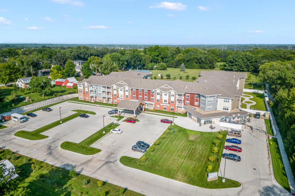 Aerial view of Meadowview of Johnston senior living community in Johnston, Iowa, showcasing the residential building, parking areas, and landscaped campus.