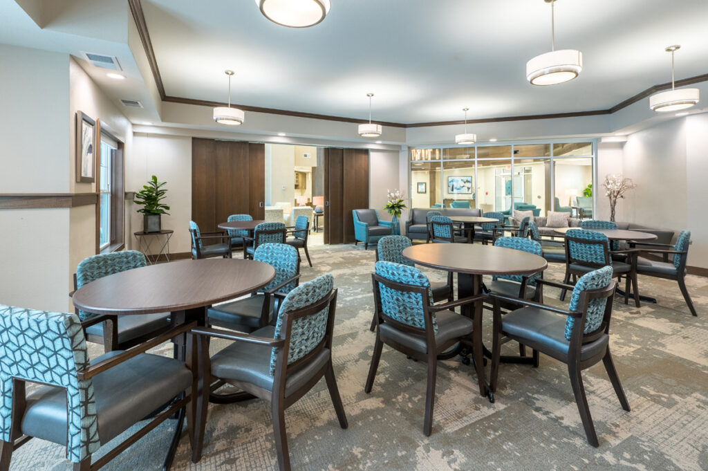 Community lounge at Meadowview of Johnston featuring comfortable seating and tables for resident gatherings, activities, and social events.