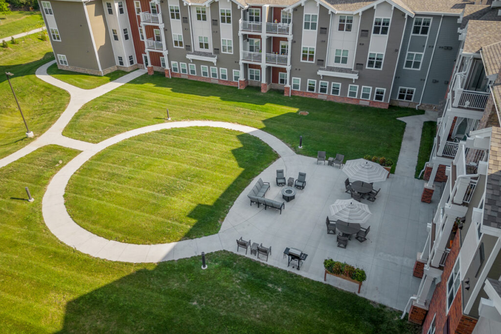Aerial view of the courtyard at Meadowview of Johnston senior living community featuring walking paths, patio seating, and landscaped green space.