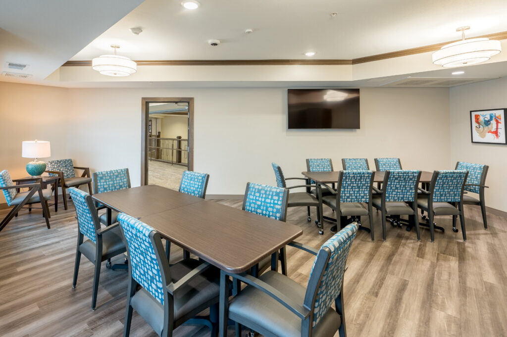 Creative studio at Meadowview of Johnston featuring resident art activities, workspace tables, and large windows with natural light.
