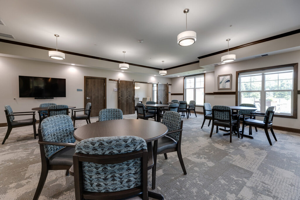 Multipurpose event space at Meadowview of Johnston featuring tables, comfortable seating, and room for resident activities, programs, and social gatherings.