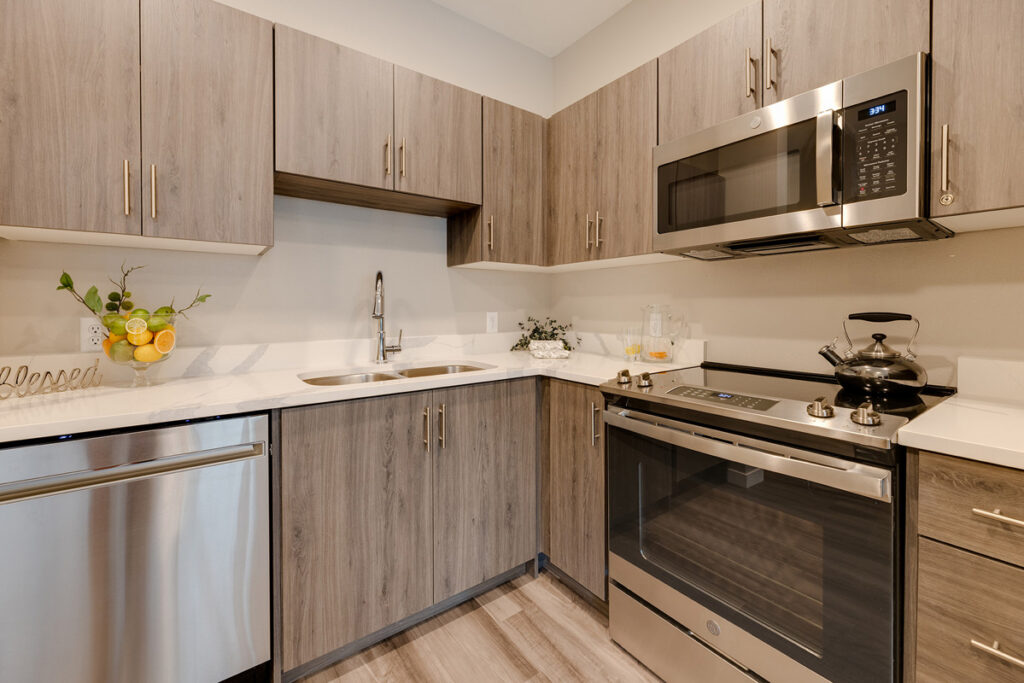 Full apartment kitchen at Meadowview of Johnston featuring stainless steel appliances, ample cabinet storage, and modern finishes.