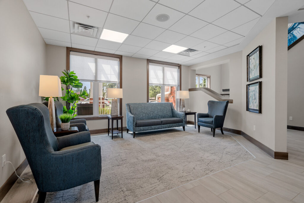 Comfortable seating area in the Meadowview of Johnston lobby featuring upholstered chairs, natural light, and views of the outdoor courtyard.