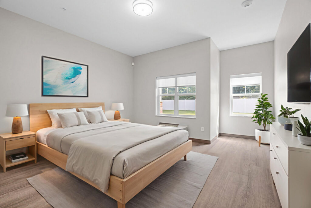 Memory care bedroom suite at Meadowview of Johnston featuring large windows, comfortable furnishings, and a bright home-like environment designed for residents with memory loss.