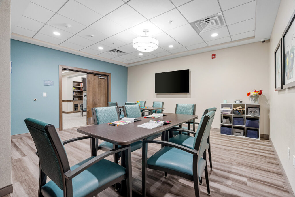 Memory care classroom at Meadowview of Johnston featuring tables, comfortable seating, and dedicated space for cognitive activities and resident engagement programs.