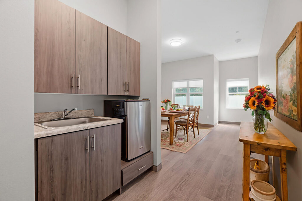 Memory care suite at Meadowview of Johnston featuring a private kitchenette, dining area, natural light, and a comfortable home-like setting for residents with memory loss.