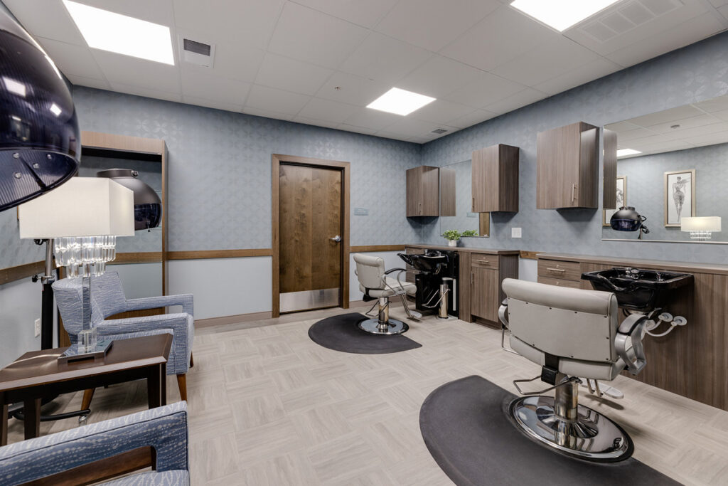 Full-service salon at Meadowview of Johnston featuring styling stations, shampoo chairs, and a comfortable space for resident personal care services.
