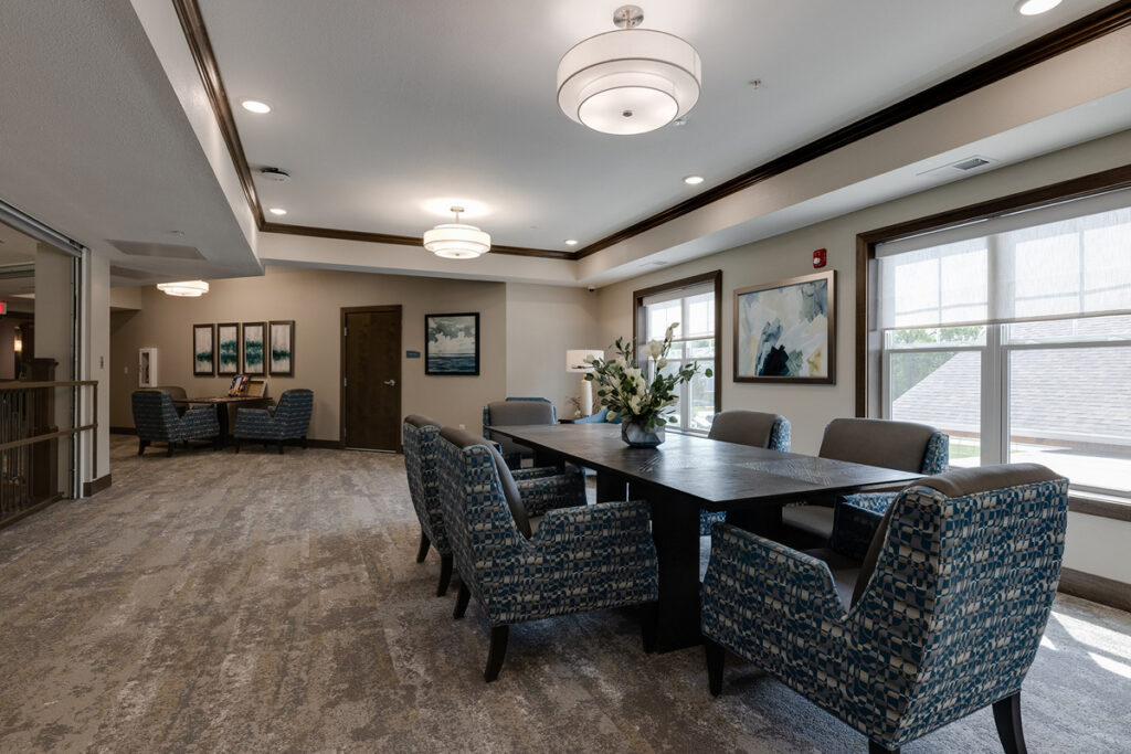 Social lounge at Meadowview of Johnston featuring comfortable seating, a shared table, and gathering space for resident activities and conversation.